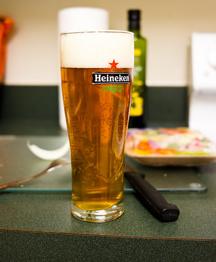 copo da marca de cerveja Heineken com chope Lager e espuma de chope