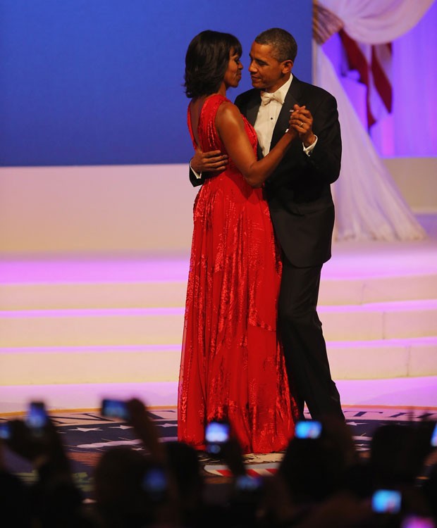 Michelle Obama com vestido vermelho dançando com Barack Obama