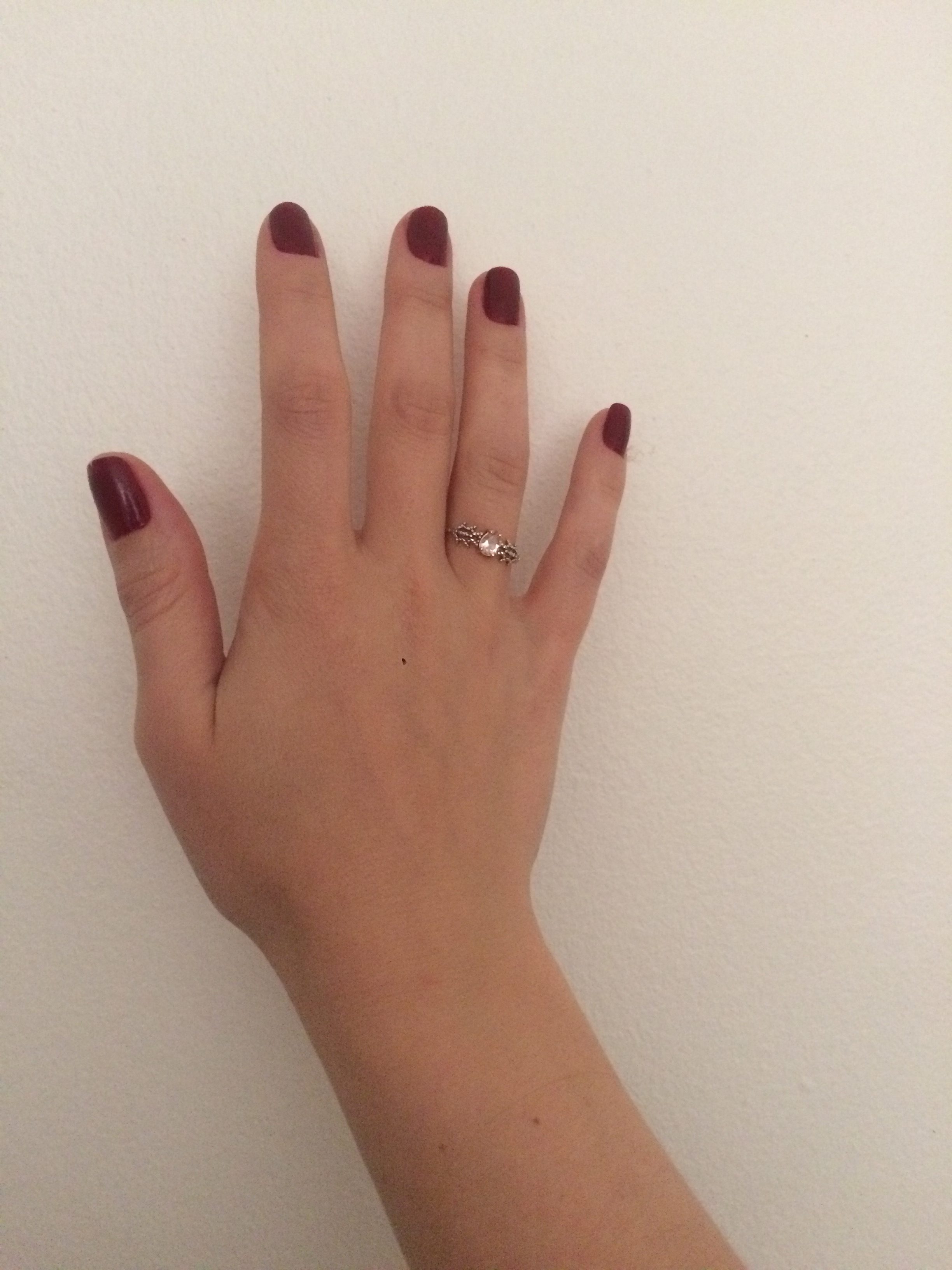 mão com o esmalte Vermelho Royal da Avon e anel de ouro