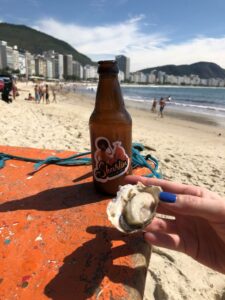 ostra com gin tônica e praia de Copacabana ao fundo